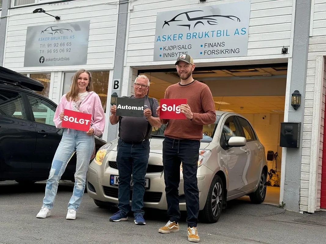 Tre mennesker foran en sølv Toyota Yaris fra Asker Bruktbil AS.
